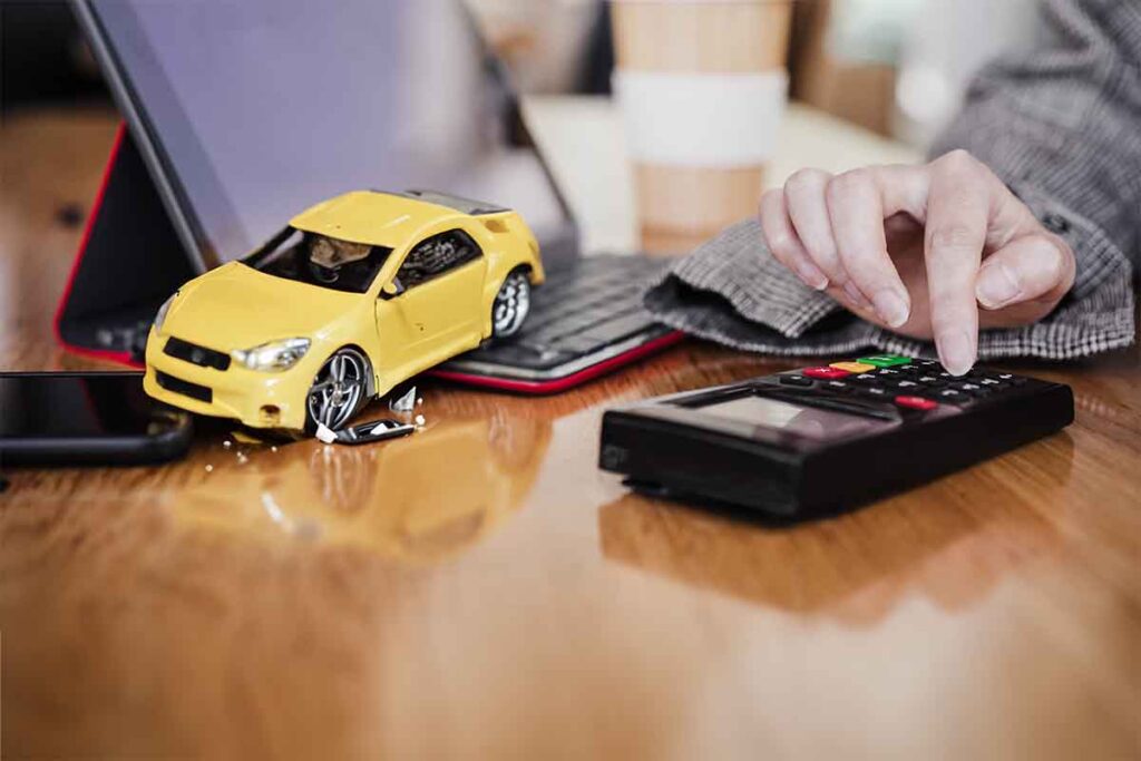 A generative AI photo illustration showing a damaged toy car next to a calculator.