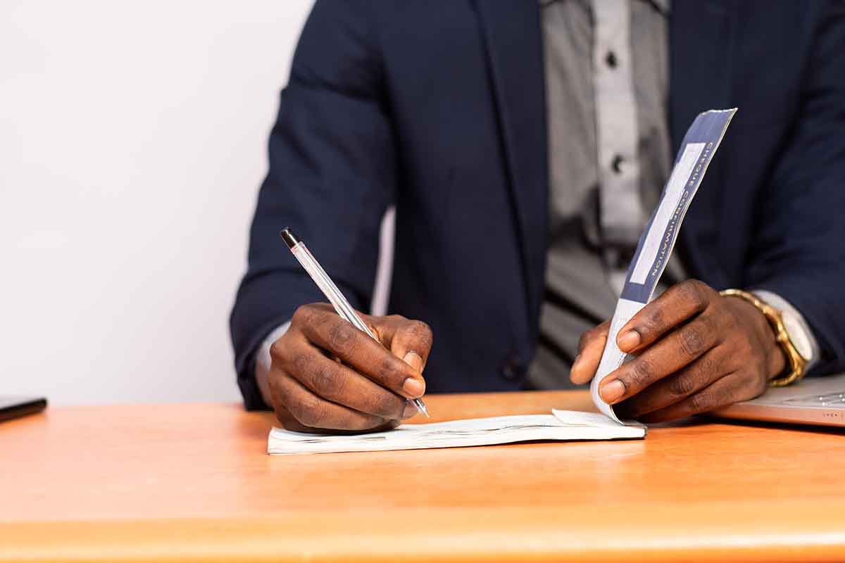 Photo illustration showing a businessman filling out a paycheck.